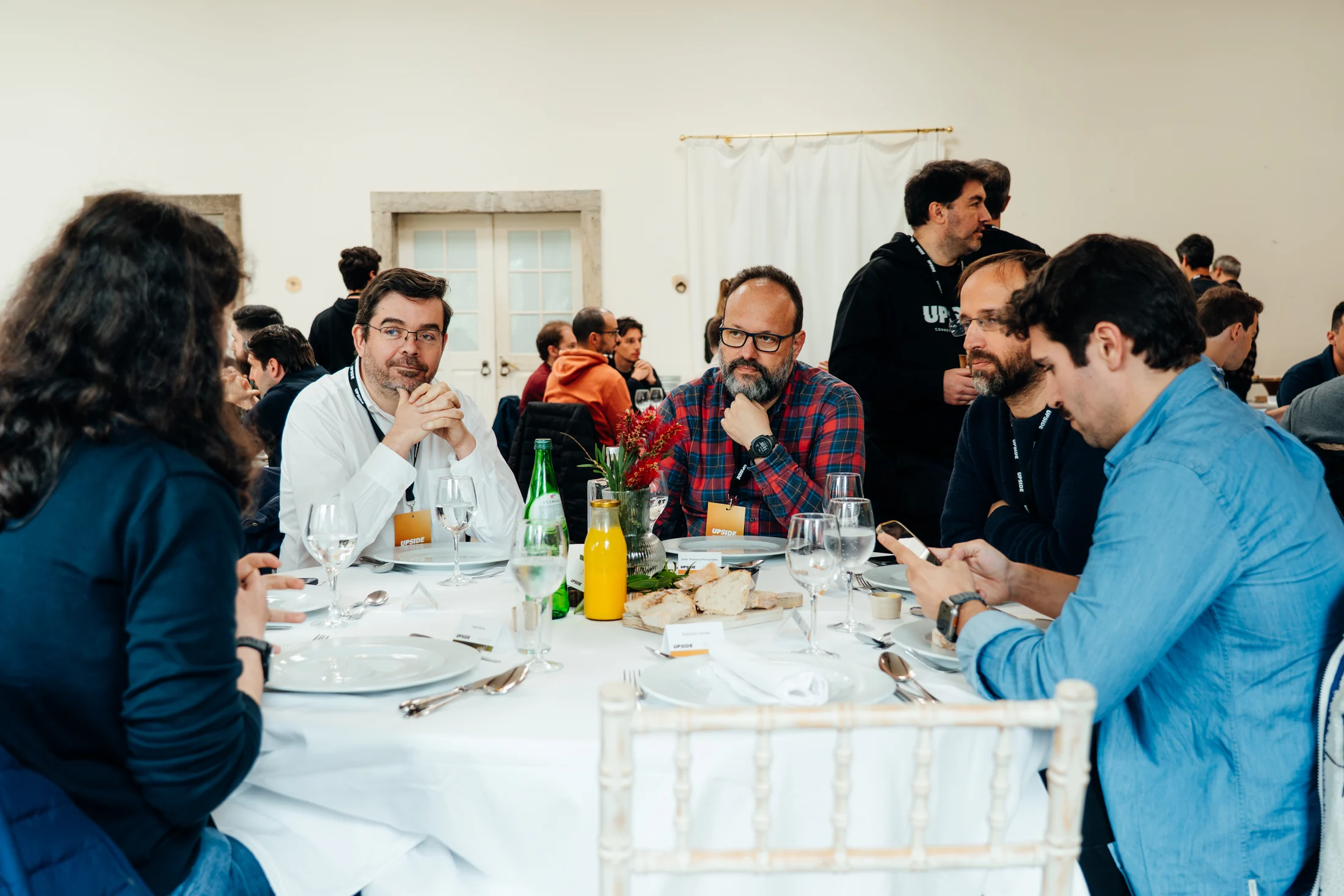 Guests sharing conversation over a meal in the Main Hall at DOMA
