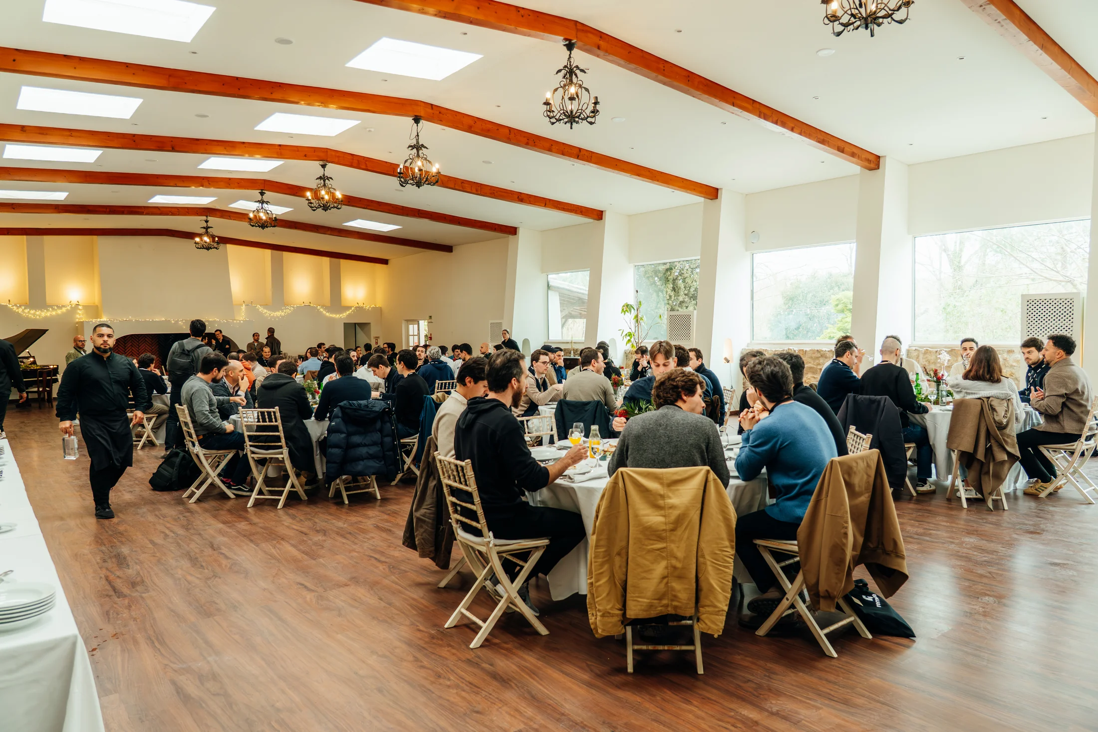 Guests sharing a daytime meal in the Main Hall at the UPSIDE Founders Retreat at DOMA